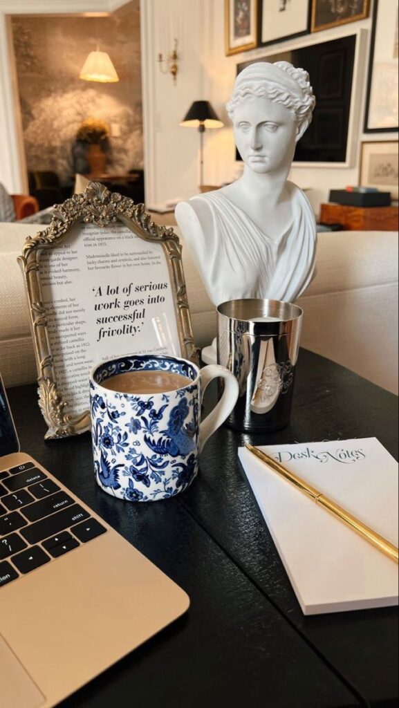 _ 22 Elegant desk scene with statue, framed quote, floral coffee mug, and laptop, enhancing a stylish workspace ambiance. | Sky Rye Design Elegant desk scene with statue, framed quote, floral coffee mug, and laptop, enhancing a stylish workspace ambiance.