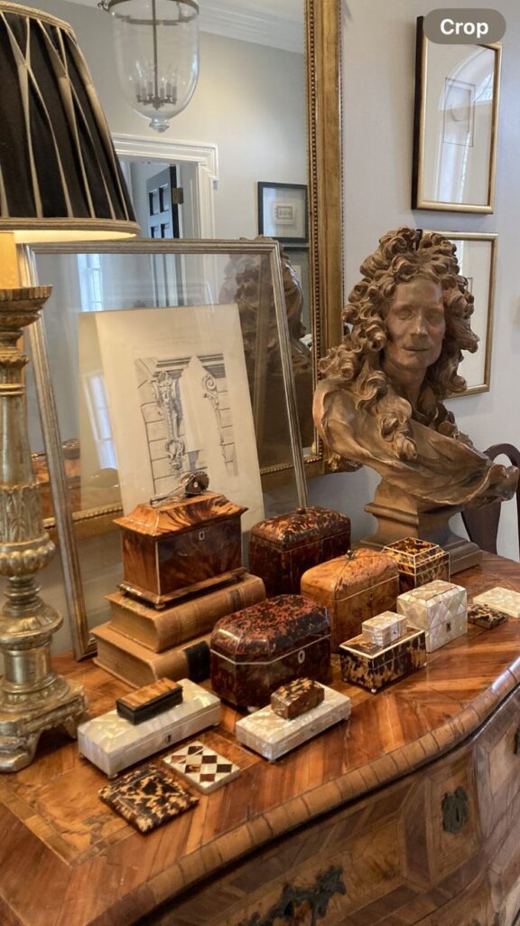 _ 23 Elegant display of antique boxes, a classical bust, and framed art on a wooden dresser in a vintage-style room. | Sky Rye Design Elegant display of antique boxes, a classical bust, and framed art on a wooden dresser in a vintage-style room.