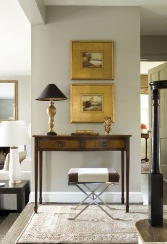 _ 23 Elegant hallway with console table, decorative lamp, and framed art, styled with a modern stool on a patterned rug. | Sky Rye Design Elegant hallway with console table, decorative lamp, and framed art, styled with a modern stool on a patterned rug.