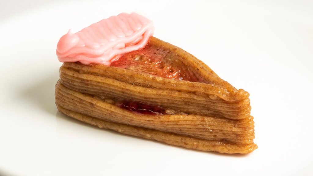 230320120156-02-3d-printing-food-cheesecake Slice of strawberry-creme mille-feuille with pink icing on a white plate, dessert perfection. | Sky Rye Design Slice of strawberry-creme mille-feuille with pink icing on a white plate, dessert perfection.