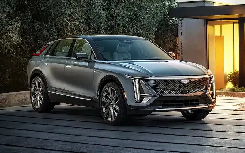 Sleek luxury electric SUV parked on a modern driveway in front of a stylish home at dusk, highlighting its innovative design and elegance.