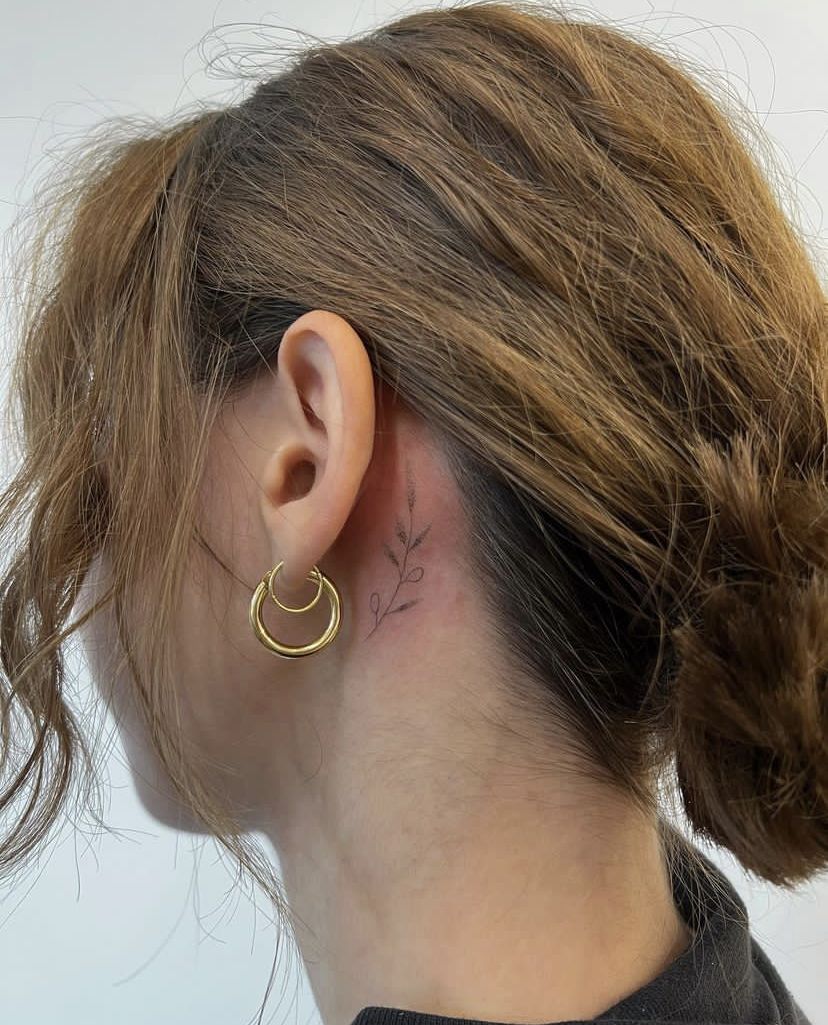 235506d3fb22347f6788252582ff2700 Woman with a small floral tattoo behind ear, wearing gold hoop earrings. | Sky Rye Design Woman with a small floral tattoo behind ear, wearing gold hoop earrings.