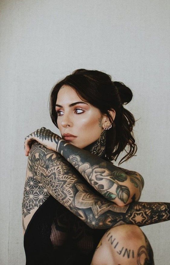 241d67feb85b1c8cb215bc40ea43383e Woman with intricate tattoos poses thoughtfully, showcasing detailed arm designs and a serene expression against a neutral background. | Sky Rye Design Woman with intricate tattoos poses thoughtfully, showcasing detailed arm designs and a serene expression against a neutral background.