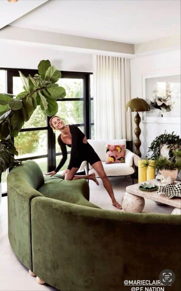 _ 27 Modern living room with a green sofa, large windows, and a person in black activewear enjoying the space. | Sky Rye Design Modern living room with a green sofa, large windows, and a person in black activewear enjoying the space.