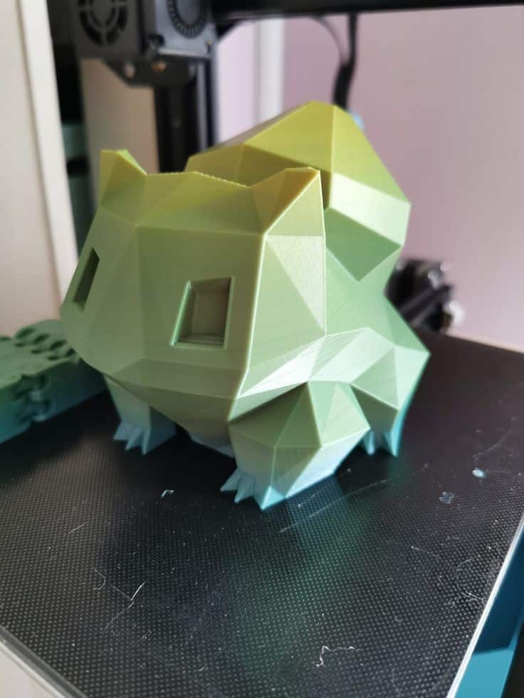 Geometric, 3D-printed green creature resembling a low-poly design, displayed on a printer bed.