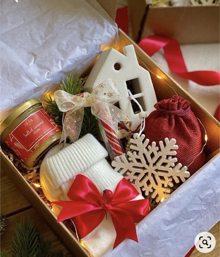 34a6c172-5b92-498c-b2cf-e2d20617b7c1 Festive gift box with holiday treats, red ribbon, ceramic house ornament, sock, salt caramel jar, and snowflake decoration. Perfect for Christmas! | Sky Rye Design Festive gift box with holiday treats, red ribbon, ceramic house ornament, sock, salt caramel jar, and snowflake decoration. Perfect for Christmas!
