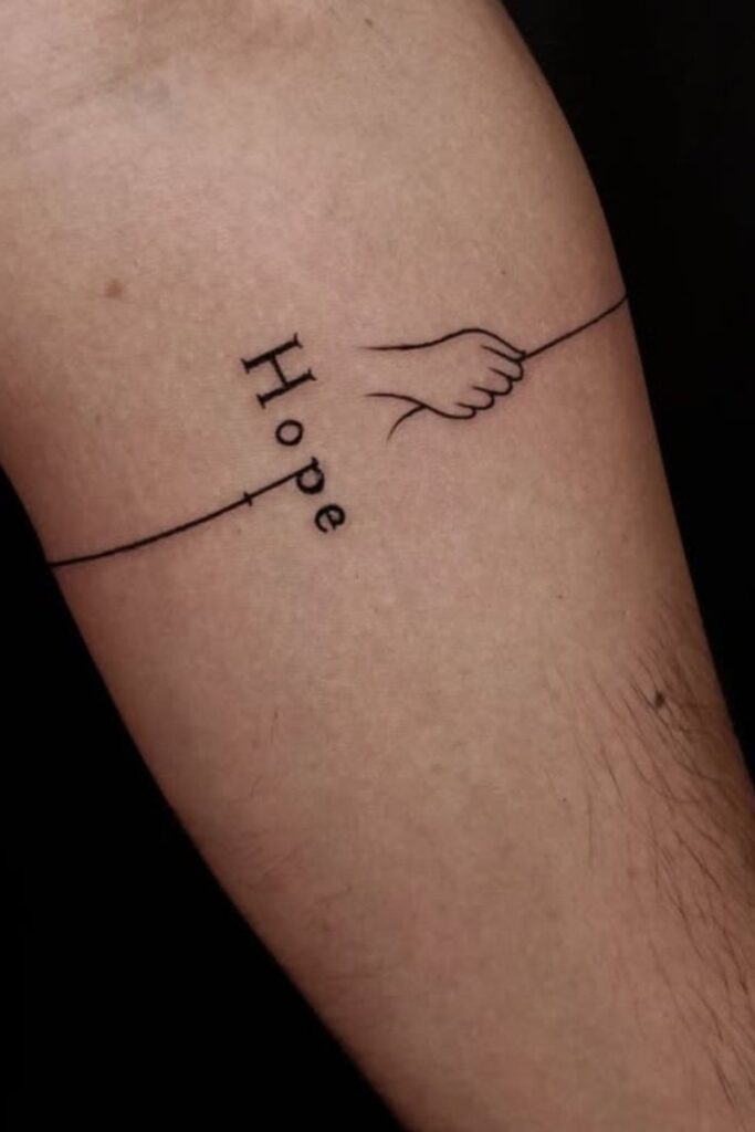 35 Powerful One-Word Tattoos To Inspire You - WomenH_com Minimalist tattoo of the word Hope with a hand gripping a line, symbolizing strength and perseverance. | Sky Rye Design Minimalist tattoo of the word Hope with a hand gripping a line, symbolizing strength and perseverance.