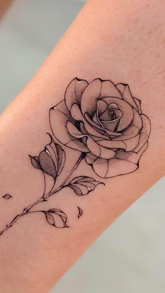 Black and grey rose tattoo on forearm, showcasing intricate shading and detailed design for a realistic floral art piece.