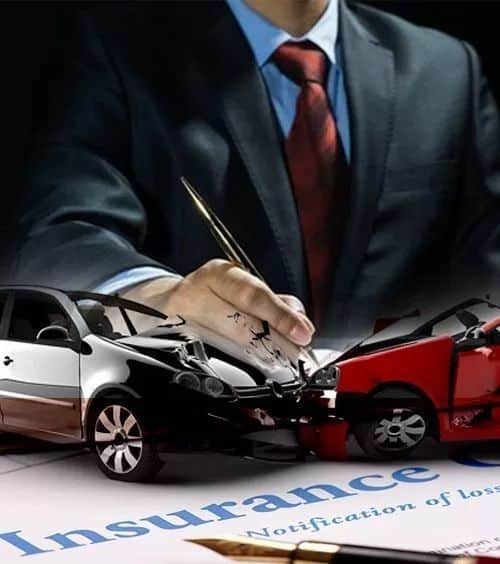 Person signing car insurance claim with images of a collision.