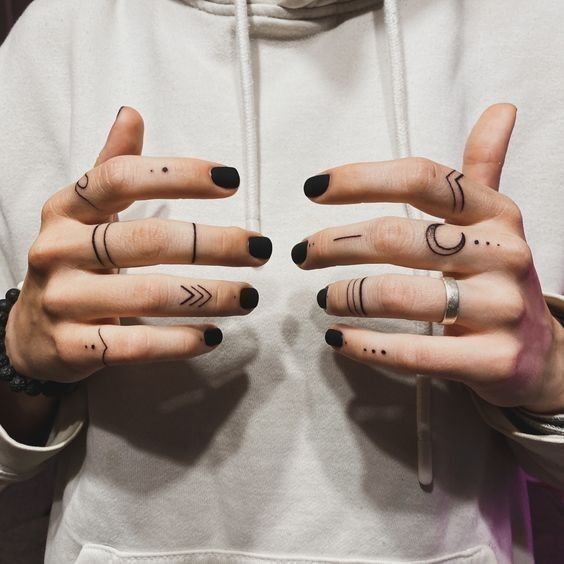396b5c2da0a4e4e3c612f5c42fa6cb26 Person showing hand tattoos with black nail polish, wearing a hoodie. Geometric and minimalist tattoo designs. | Sky Rye Design Person showing hand tattoos with black nail polish, wearing a hoodie. Geometric and minimalist tattoo designs.