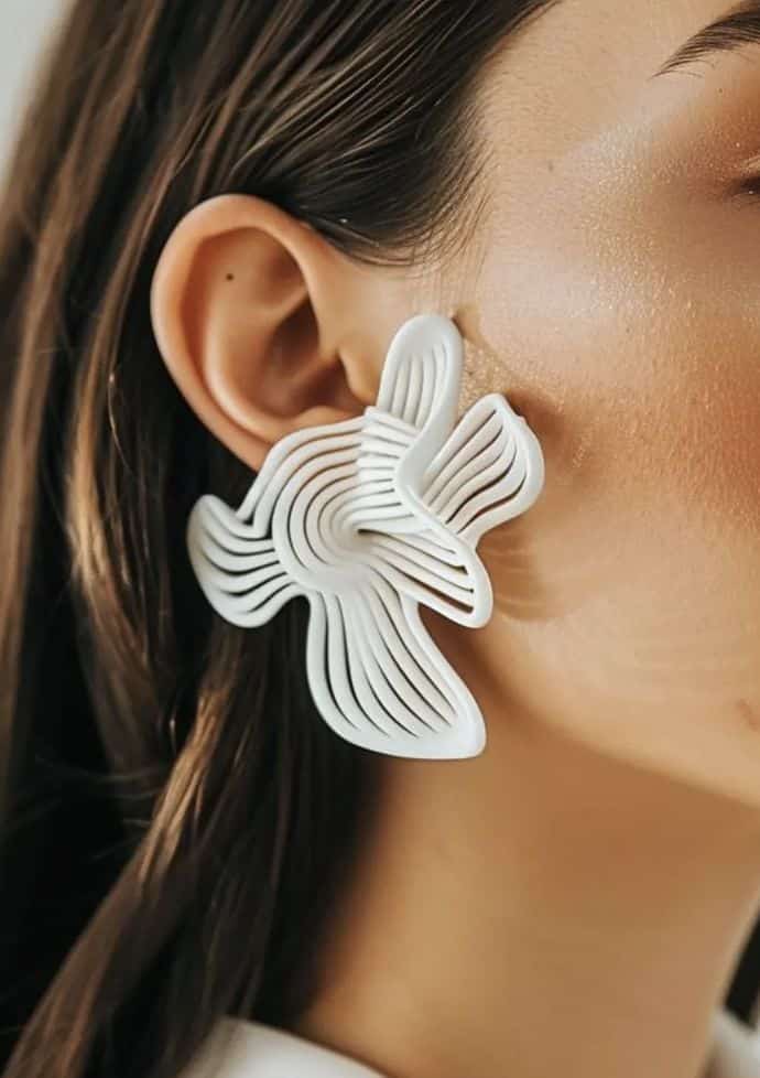 Screenshot Unique white abstract earrings on a woman, showcasing modern fashion and contemporary jewelry design with artistic flair. | Sky Rye Design Unique white abstract earrings on a woman, showcasing modern fashion and contemporary jewelry design with artistic flair.