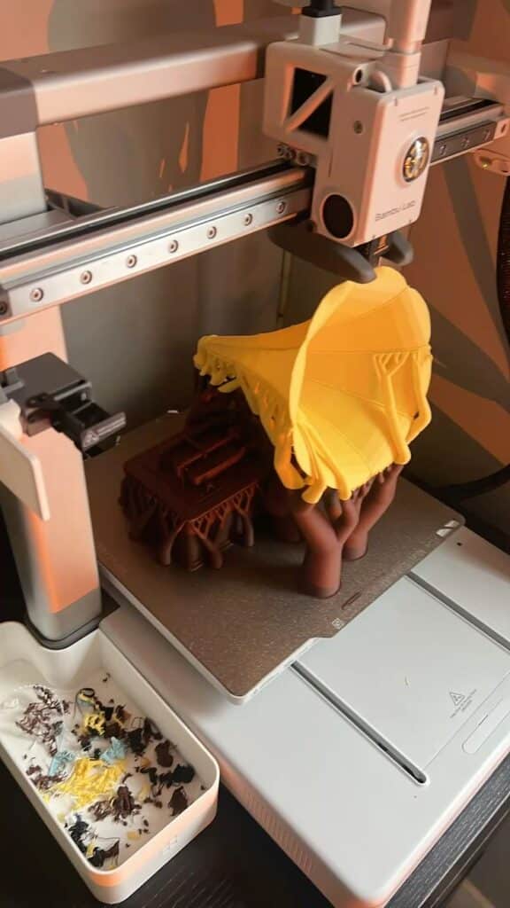 3D printer creating a miniature treehouse model with a yellow roof, showcasing intricate design and craftsmanship. best 3d printer for toys