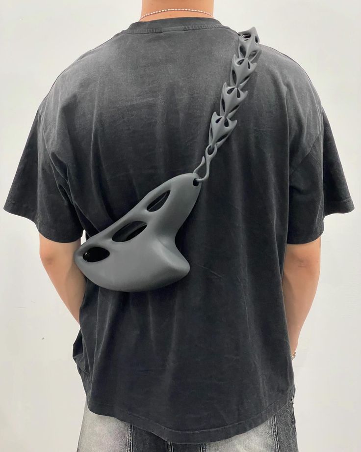 3d-printed bag accessories jewelry bracelet ring necklace pendant earings futuristic futuristicfashion bag Modern black crossbody bag with unique cut-out design, worn by person in a casual black t-shirt and jeans, viewed from the back. | Sky Rye Design Modern black crossbody bag with unique cut-out design, worn by person in a casual black t-shirt and jeans, viewed from the back.