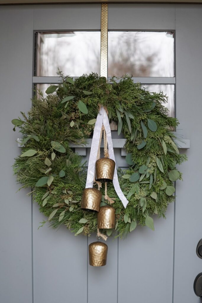 3f4a57326057734b60a3b1773dc9024b Festive evergreen wreath with gold bells and ribbon on a gray door, perfect for holiday decoration and seasonal cheer. | Sky Rye Design Festive evergreen wreath with gold bells and ribbon on a gray door, perfect for holiday decoration and seasonal cheer.