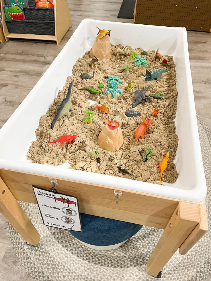 _ 4 Children's interactive dinosaur sandbox featuring toy dinosaurs and volcanoes, ideal for imaginative play and learning in educational settings. | Sky Rye Design Children's interactive dinosaur sandbox featuring toy dinosaurs and volcanoes, ideal for imaginative play and learning in educational settings.