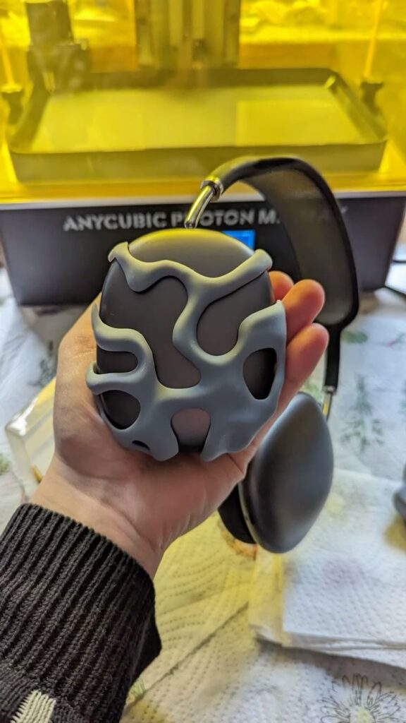 _ 4 Hand holding a unique 3D-printed object with abstract design, in front of a 3D printer, showcasing creative printing capabilities. | Sky Rye Design Hand holding a unique 3D-printed object with abstract design, in front of a 3D printer, showcasing creative printing capabilities.