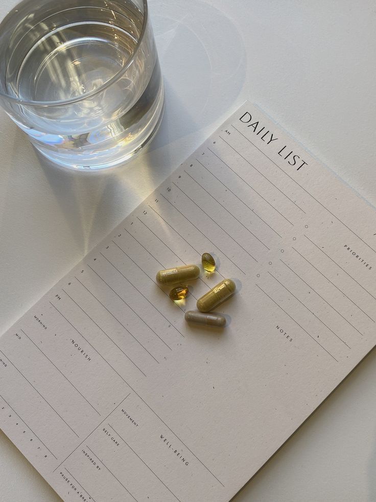 _ 4 Glass of water and supplements on a Daily List planner, promoting wellness and productivity. | Sky Rye Design Glass of water and supplements on a Daily List planner, promoting wellness and productivity.