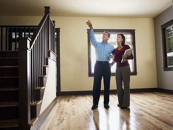45 Of The Most Popular House Styles In The United States Real estate agent showing a house to a client, pointing out details in a well-lit room with wooden flooring. | Sky Rye Design Real estate agent showing a house to a client, pointing out details in a well-lit room with wooden flooring.