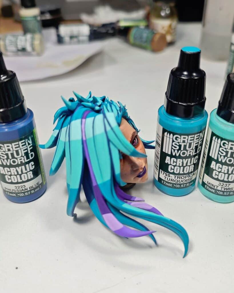 4c5613c6cc0700b6d73a7389ff71be80 Colorful sculpted head with vibrant turquoise and purple hair, surrounded by Green Stuff World acrylic paints. | Sky Rye Design Colorful sculpted head with vibrant turquoise and purple hair, surrounded by Green Stuff World acrylic paints.