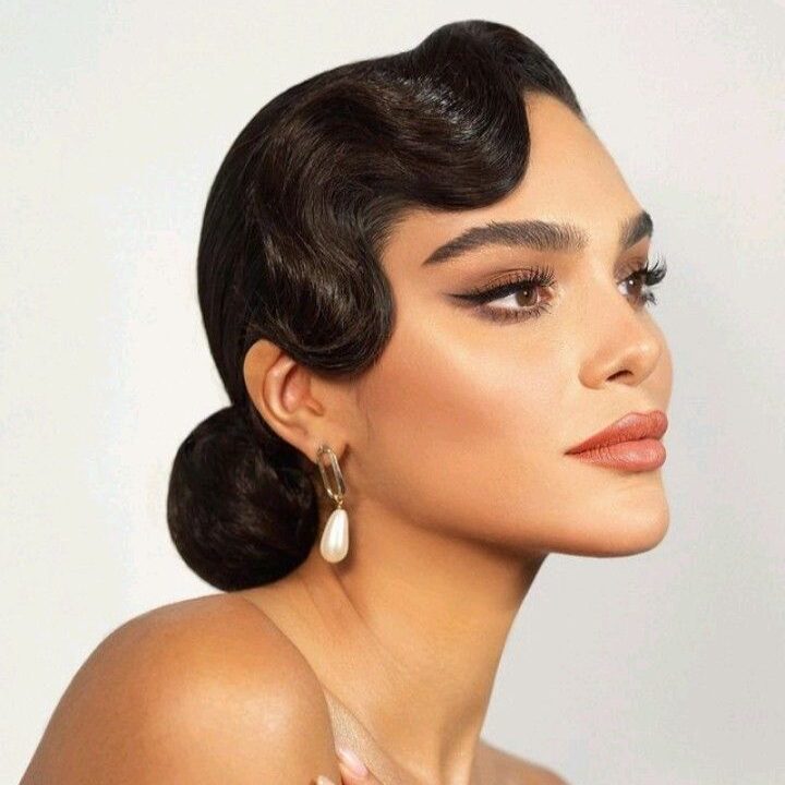 4c8fa076b04bf0ab0760fd526671b95a Elegant woman with vintage hairstyle, bold makeup, pearl earring, and diamond ring in a stylish pose against a neutral background. | Sky Rye Design Elegant woman with vintage hairstyle, bold makeup, pearl earring, and diamond ring in a stylish pose against a neutral background.