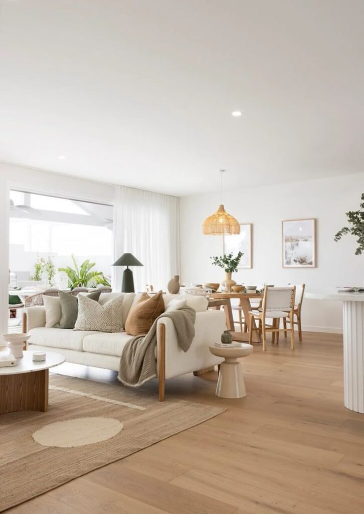 Modern living room with cozy sofa, neutral décor, wooden accents, and natural lighting. Minimalist and inviting interior design.