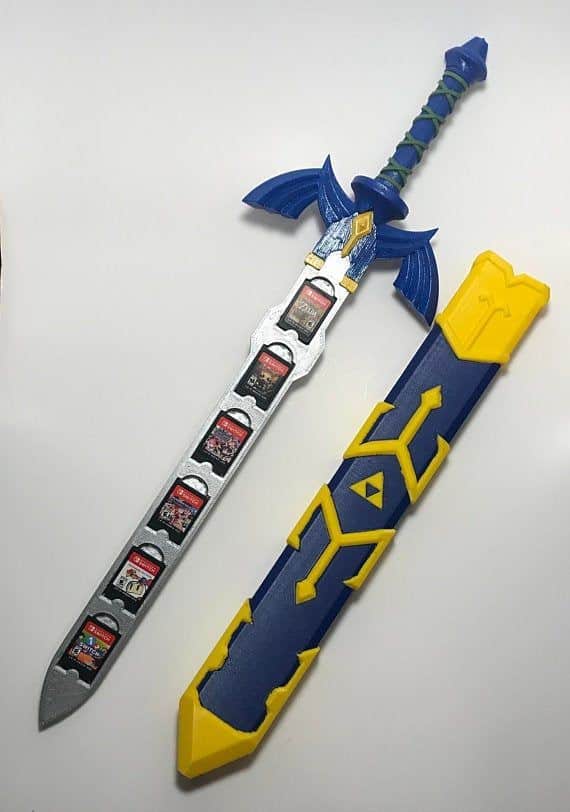 Blue and silver fantasy sword displaying video game cartridges on blade, paired with a matching blue and yellow scabbard.