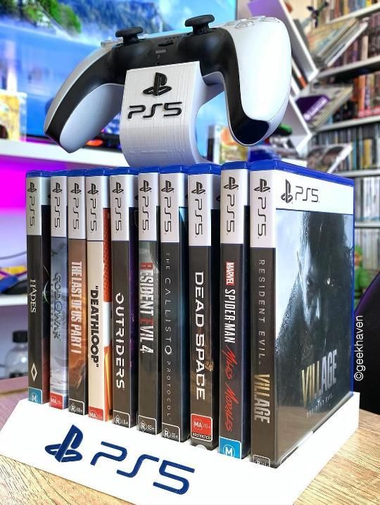 PS5 controller displayed with a collection of popular game cases, showcasing diverse titles in a gaming setup.