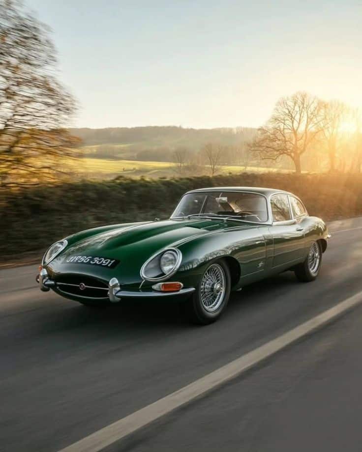 5b9518deaf2ebb8a3da8729d877c03c3 Classic green sports car driving on a scenic country road at sunset, showcasing vintage elegance and timeless design. | Sky Rye Design Classic green sports car driving on a scenic country road at sunset, showcasing vintage elegance and timeless design.