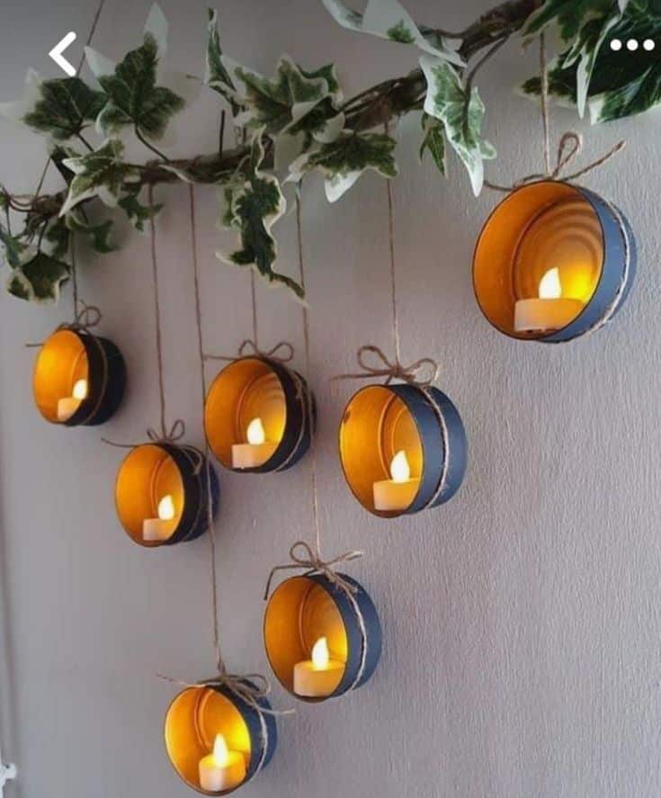 Hanging tealights in circular holders on a wall with greenery, creating a warm, cozy ambiance. Perfect for home decor and styling ideas.