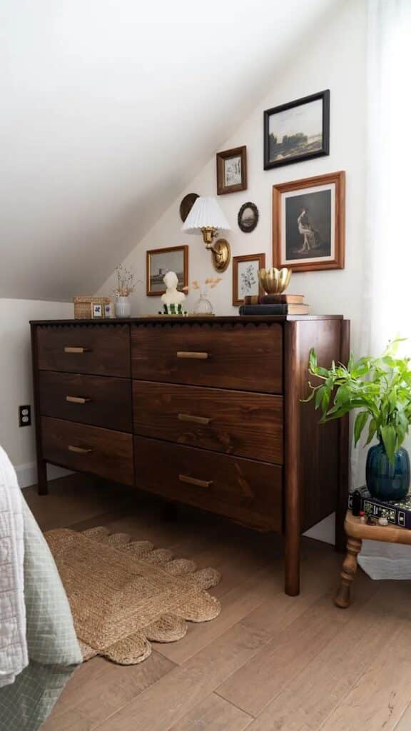 _ 6 Wooden dresser with vintage decor, framed art, houseplant, and table lamp in cozy, stylish room. | Sky Rye Design Wooden dresser with vintage decor, framed art, houseplant, and table lamp in cozy, stylish room.