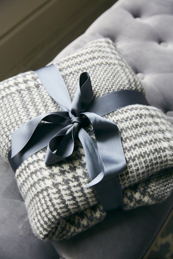 6 Ingenious Wrapping Paper Alternatives That Will Leave You Breathless Gray houndstooth blanket neatly wrapped with a satin ribbon, placed on a tufted surface, ideal for cozy winter gifts. | Sky Rye Design Gray houndstooth blanket neatly wrapped with a satin ribbon, placed on a tufted surface, ideal for cozy winter gifts.
