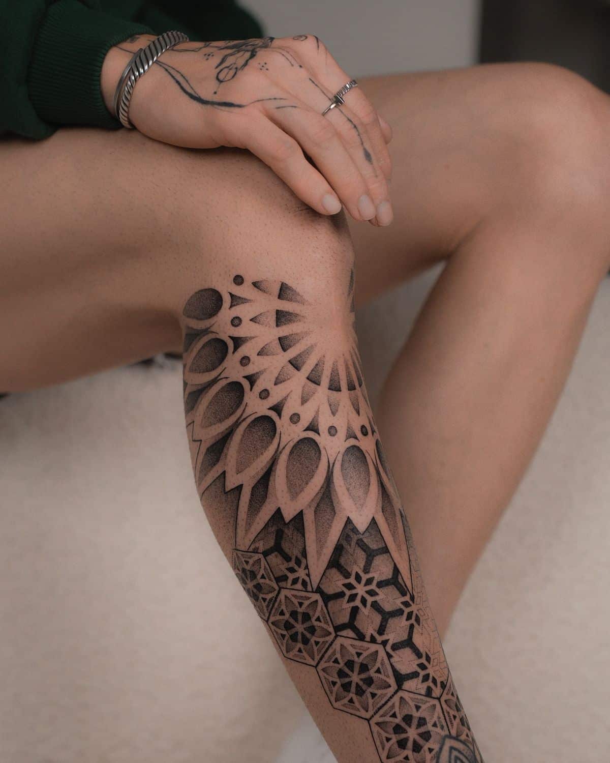 Dot work tattoo on leg and hand with layered geometric patterns and shaded ornamental details Dot work tattoo on leg and hand with layered geometric patterns and shaded ornamental details. | Sky Rye Design Dot work tattoo on leg and hand with layered geometric patterns and shaded ornamental details.