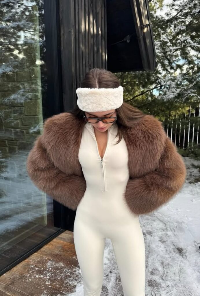 Fashionable winter outfit with faux fur jacket and headband in snowy outdoor setting.