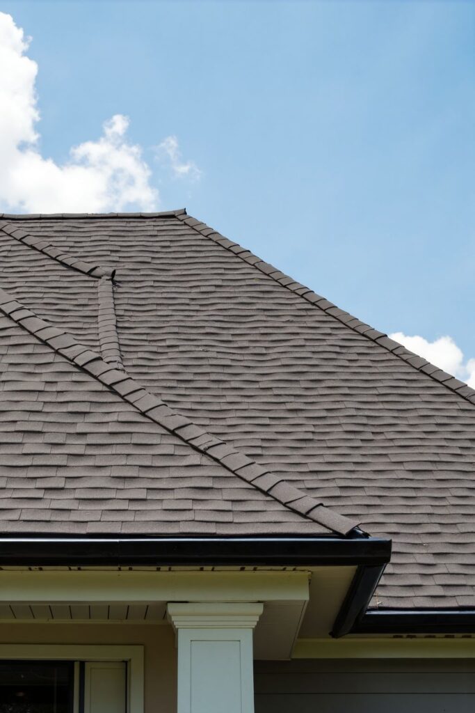 6f81332068a5cc835e8b5dc634751d7c Close-up of modern asphalt shingle roof with blue sky background, showcasing durable construction. | Sky Rye Design Close-up of modern asphalt shingle roof with blue sky background, showcasing durable construction.