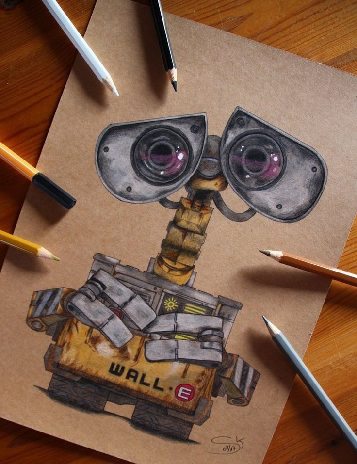 Drawing of a robot on paper surrounded by colored pencils, showcasing a detailed illustration in realistic style.