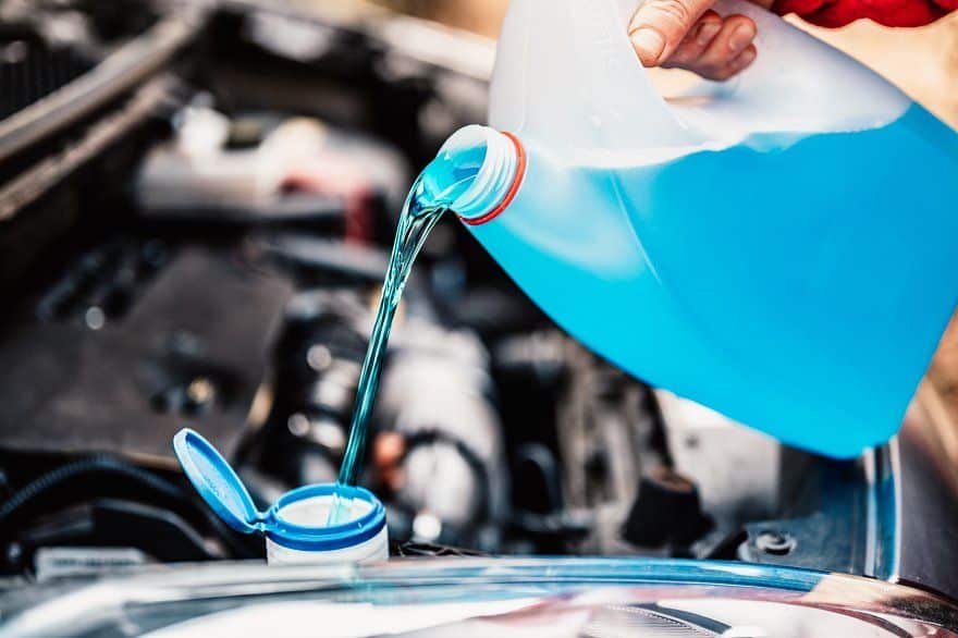 81193f55d090ca0348b6377bd6970dea Pouring blue windshield washer fluid into car engine compartment. Essential vehicle maintenance to improve visibility. | Sky Rye Design Pouring blue windshield washer fluid into car engine compartment. Essential vehicle maintenance to improve visibility.