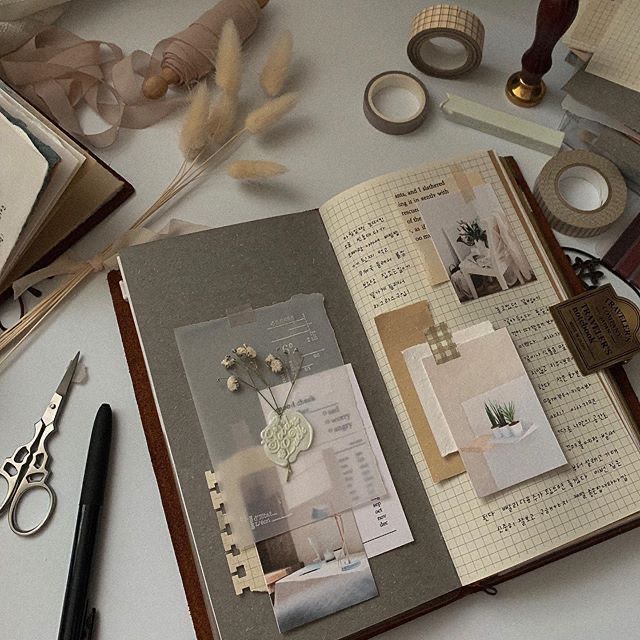 Vintage scrapbook journal with dried flowers, decorative tape, and paper cutouts, perfect for creative journaling enthusiasts.