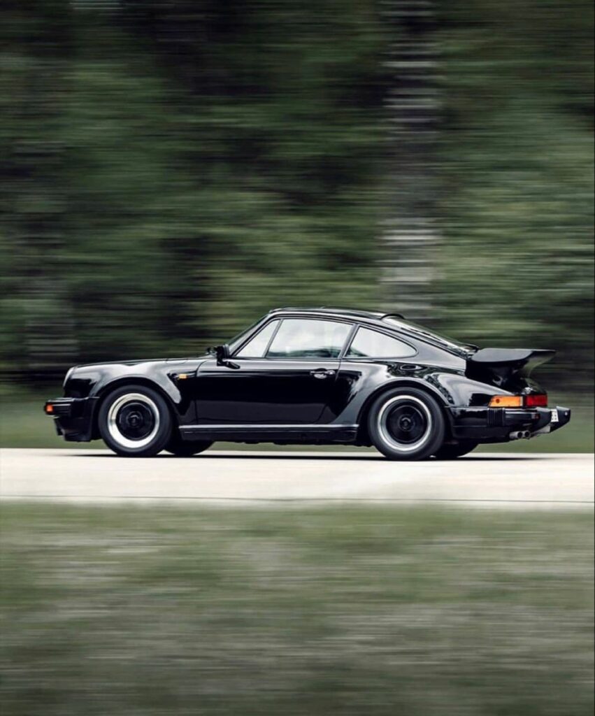 8c6cb4a1e71af21257f6006906577276 Classic black sports car driving fast along a scenic road with blurred forest background. Perfect blend of speed, style, and nature. | Sky Rye Design Classic black sports car driving fast along a scenic road with blurred forest background. Perfect blend of speed, style, and nature.