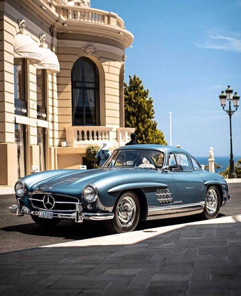 8d4e6f9fd48894f43b872736048b51f8 Classic blue Mercedes-Benz parked in front of an elegant building with a clear blue sky, embodying luxury and timeless design. | Sky Rye Design Classic blue Mercedes-Benz parked in front of an elegant building with a clear blue sky, embodying luxury and timeless design.