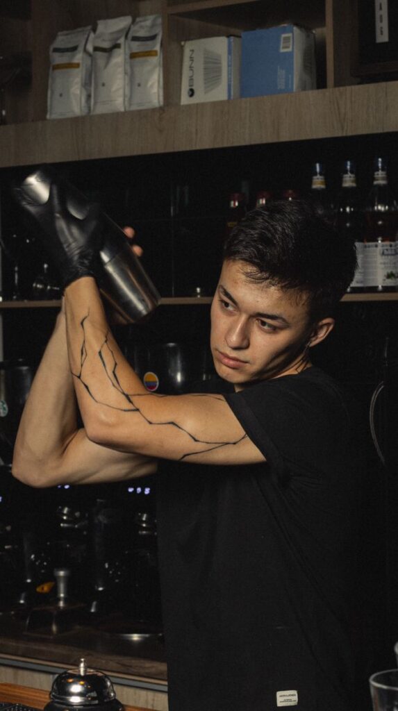 8de444b70caa0d0c31f795b96d22c250 Bartender skillfully shaking cocktail shaker in a stylish bar setting. | Sky Rye Design Bartender skillfully shaking cocktail shaker in a stylish bar setting.