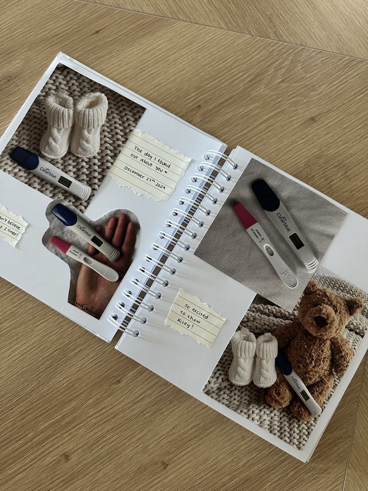 Pregnancy reveal scrapbook with tests, baby socks, and teddy bear, celebrating the exciting news of expecting a baby.