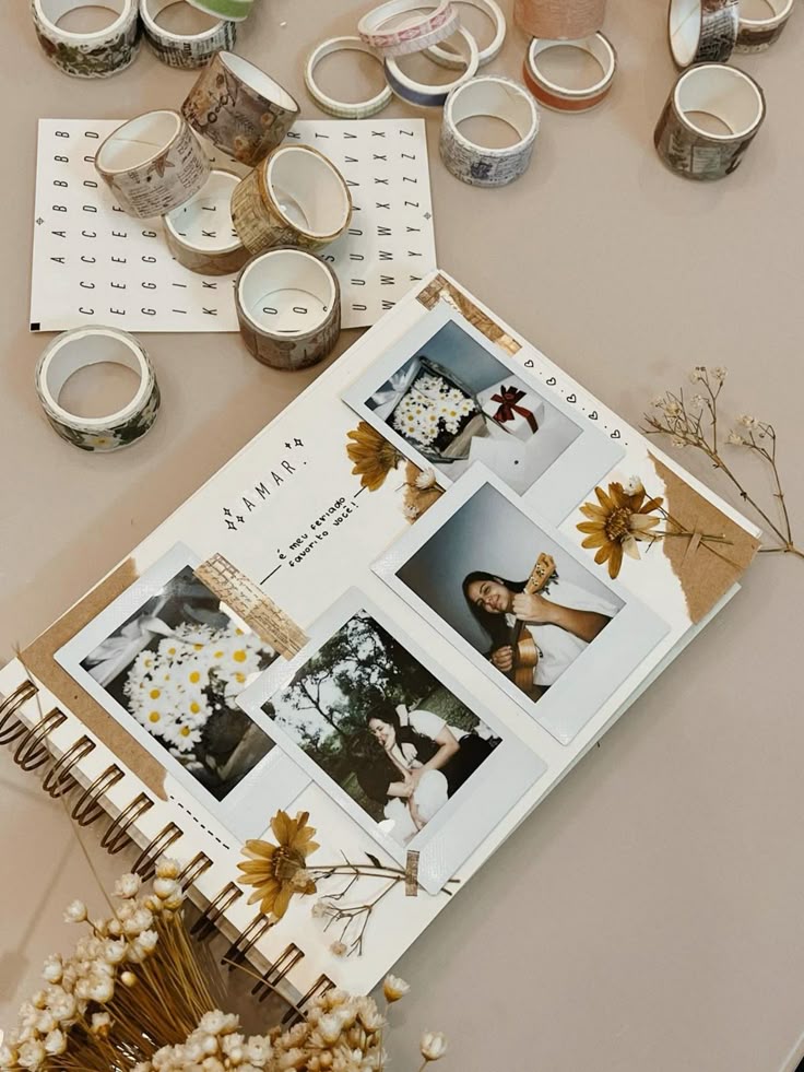 Scrapbook with Polaroid photos, dried flowers, and decorative tape on a beige surface, featuring creative journaling elements.