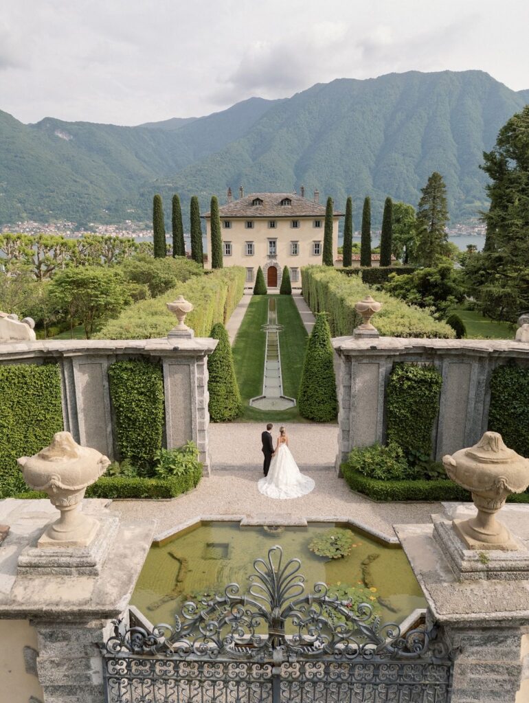 9a92e18d3080bcc565660458d9739b69 Bride and groom in elegant garden with villa and mountain backdrop, perfect wedding venue in picturesque setting. | Sky Rye Design Bride and groom in elegant garden with villa and mountain backdrop, perfect wedding venue in picturesque setting.