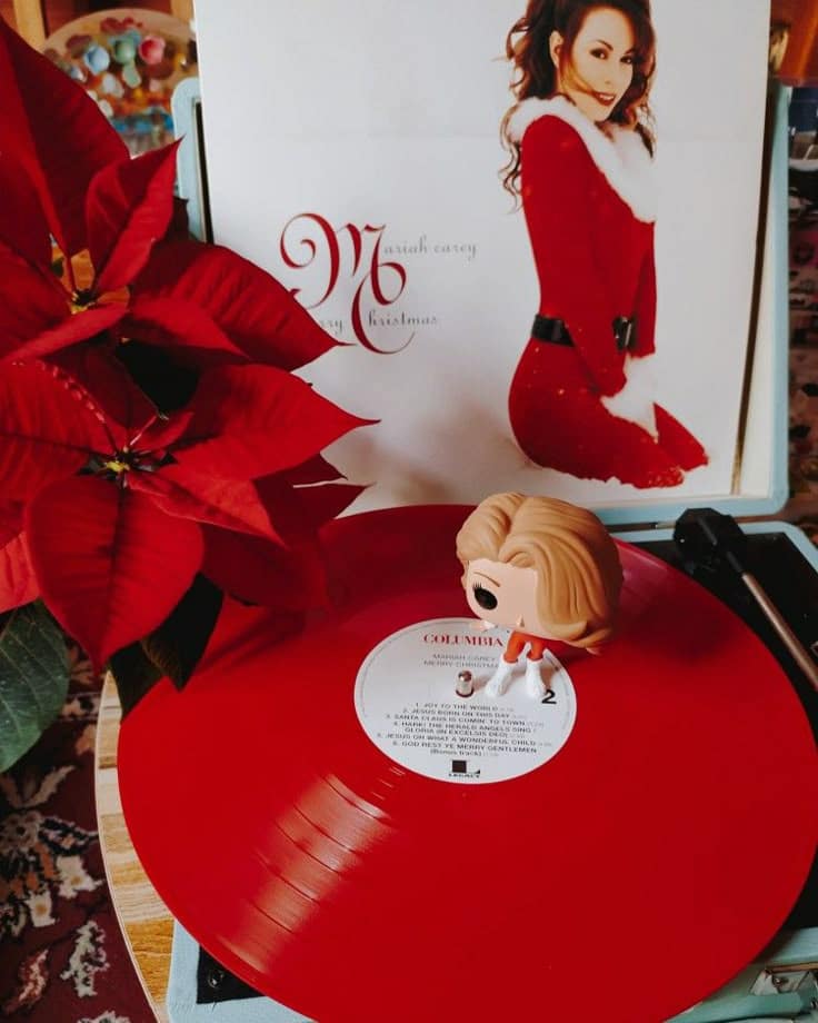 All i wanted for Christmasi almost got_ Red vinyl record with holiday album cover and festive toy figure beside poinsettia. | Sky Rye Design Red vinyl record with holiday album cover and festive toy figure beside poinsettia. Christmas hits