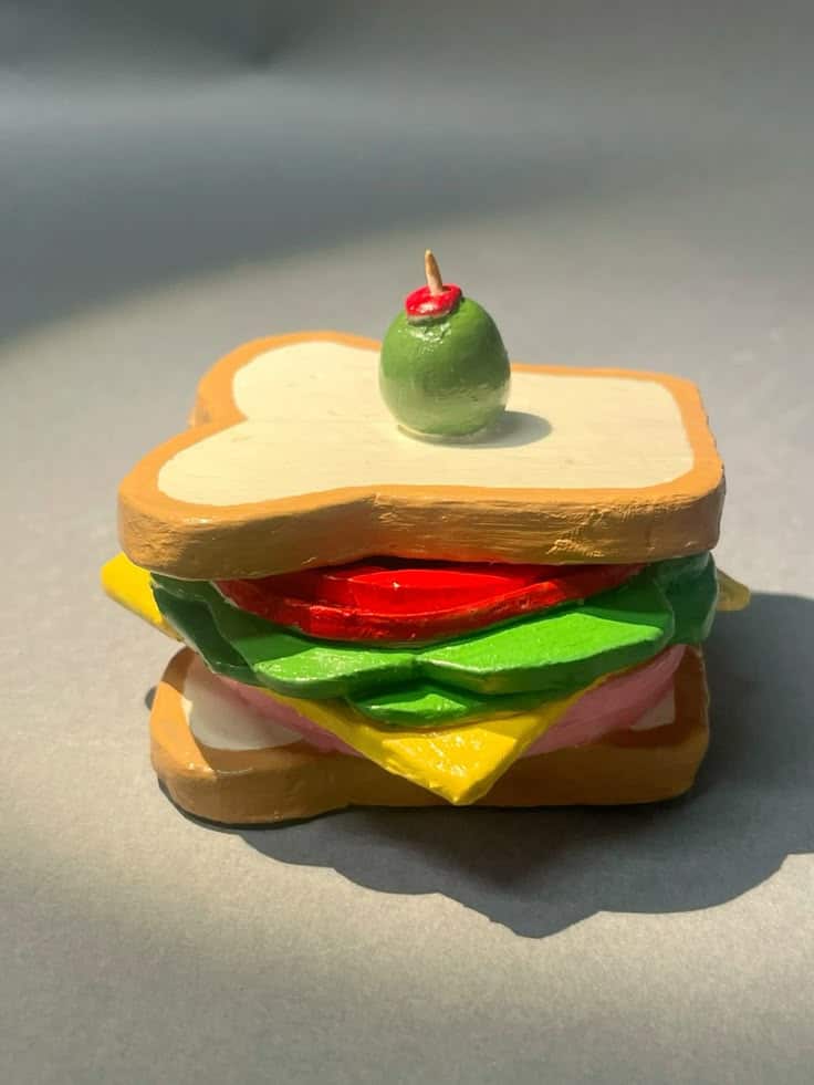 Ceramic sandwich Clay sandwich model with layers of colorful ingredients and a green olive on top, illuminated by sunlight. | Sky Rye Design Clay sandwich model with layers of colorful ingredients and a green olive on top, illuminated by sunlight.