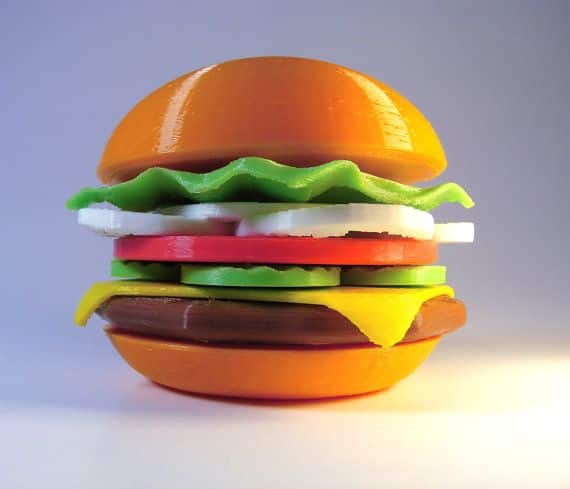 Cheeseburger Toys hamburger nifty guy decor 3d Colorful plastic toy hamburger with layers of lettuce, cheese, tomato, and onions on a bun. | Sky Rye Design Colorful plastic toy hamburger with layers of lettuce, cheese, tomato, and onions on a bun.