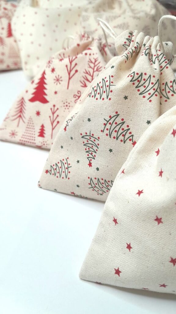 Christmas fabric gift bags Zero-waste gift wrapping Reusable and eco friendly Handmade UK Cotton festive wrapping Festive drawstring gift bags with red and green Christmas tree and star patterns, perfect for holiday wrapping and decor. | Sky Rye Design Festive drawstring gift bags with red and green Christmas tree and star patterns, perfect for holiday wrapping and decor.