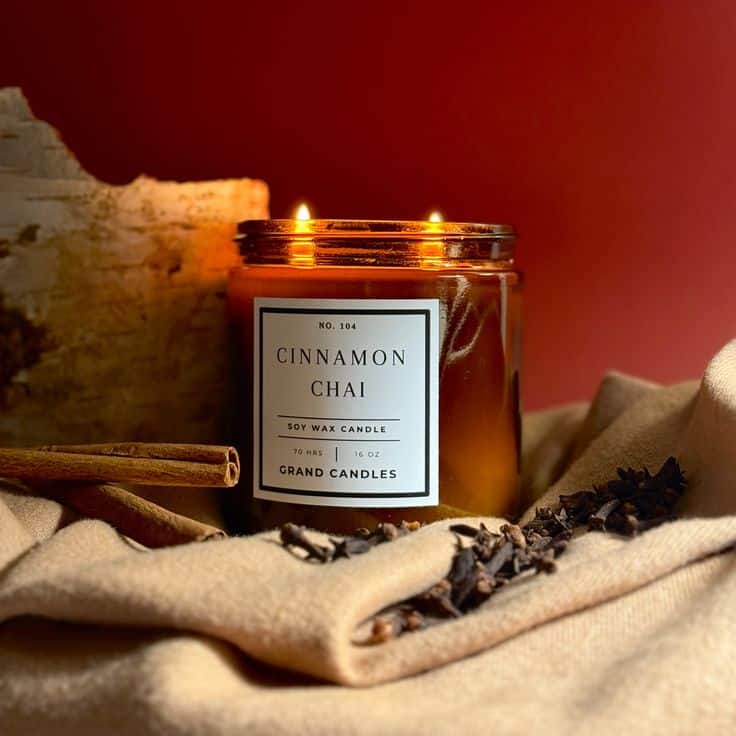 Cinnamon Chai Candle - Clear 26 oz - Apothecary Jar Cinnamon chai soy wax candle with warm glow, surrounded by spices and fabric, on a rustic background. Perfect for cozy ambiance. | Sky Rye Design Cinnamon chai soy wax candle with warm glow, surrounded by spices and fabric, on a rustic background. Perfect for cozy ambiance.