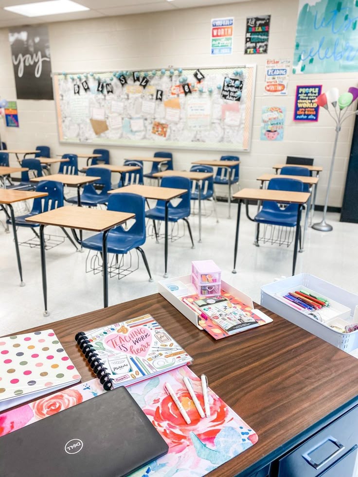 Classroom Must-Haves for Educators This School Year Classroom with desks, student notebooks, and colorful decor, viewed from a teacher's organized desk with teaching materials displayed. | Sky Rye Design Classroom with desks, student notebooks, and colorful decor, viewed from a teacher's organized desk with teaching materials displayed.