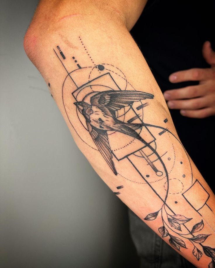 Colins_ink 🤠 Geometric bird tattoo on forearm with abstract lines and leaf designs. | Sky Rye Design Geometric bird tattoo on forearm with abstract lines and leaf designs.